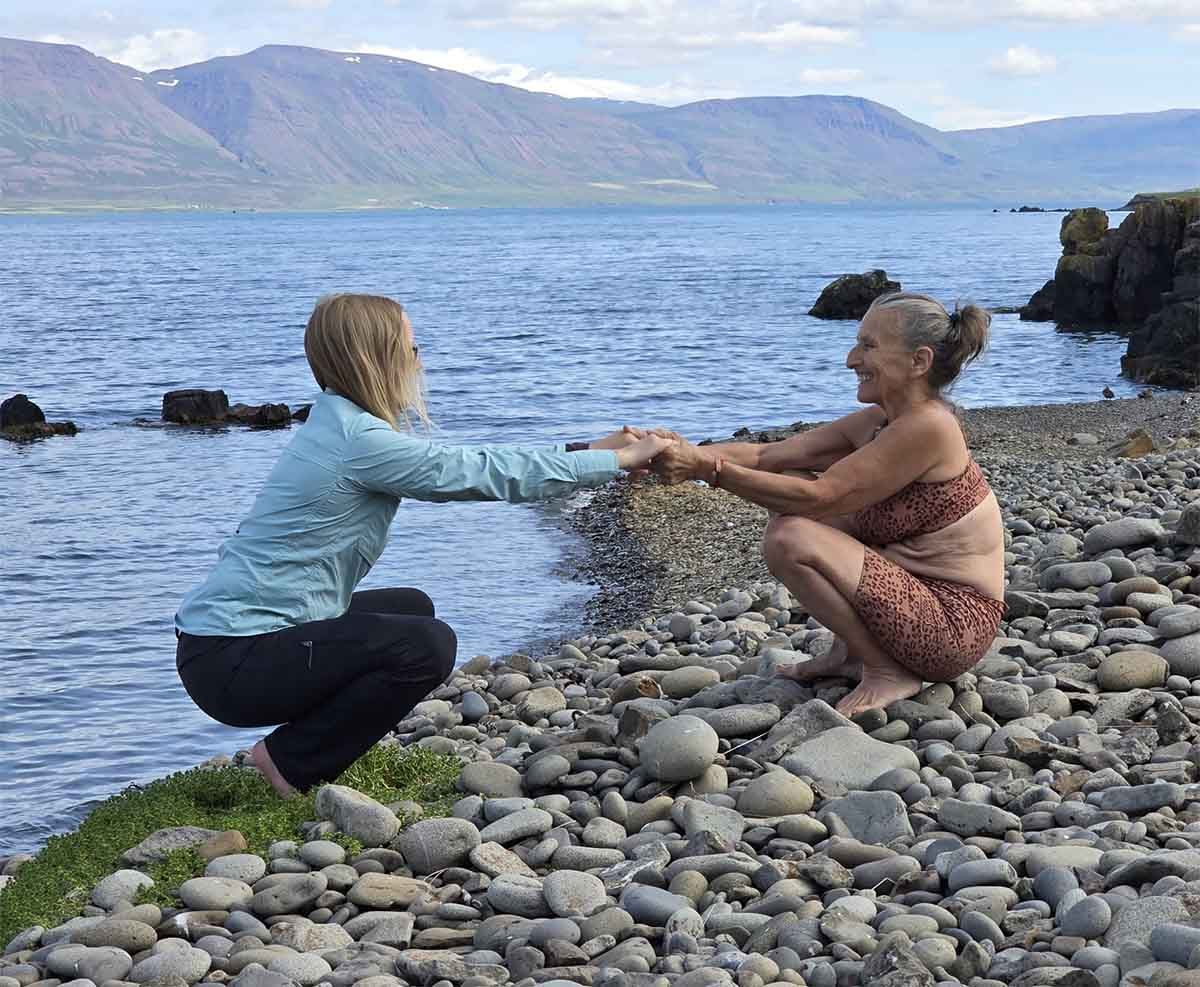 People on the shore of a fjord in Iceland